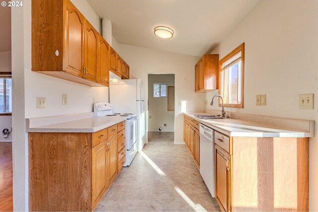 kitchen with lofted ceiling, sink, and white appliances