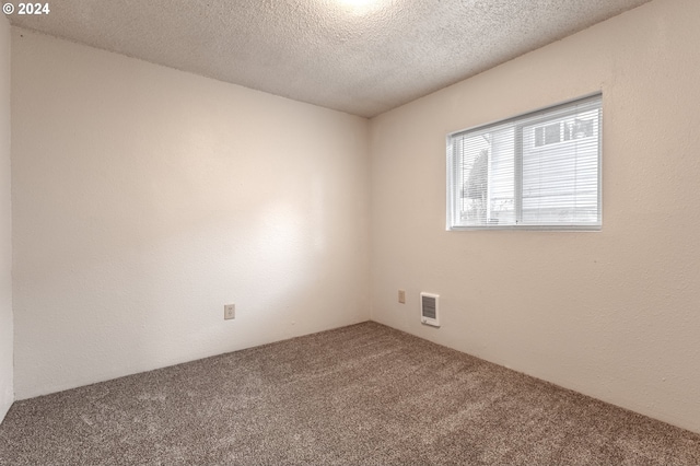 carpeted spare room featuring a textured ceiling