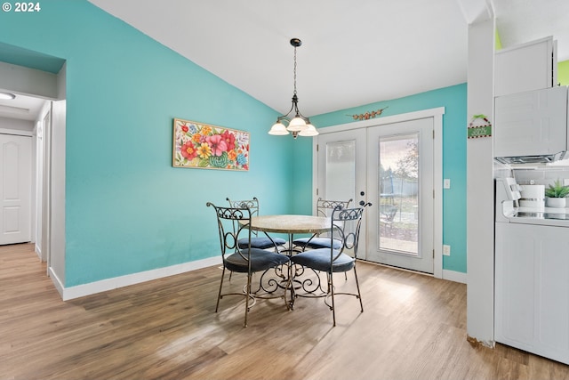 dining space with washer / clothes dryer, french doors, light hardwood / wood-style floors, and lofted ceiling