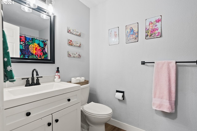 bathroom with vanity, toilet, and wood-type flooring