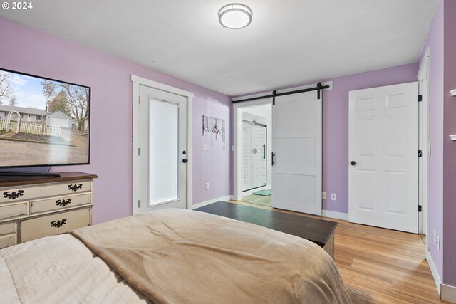 bedroom featuring hardwood / wood-style floors and a barn door