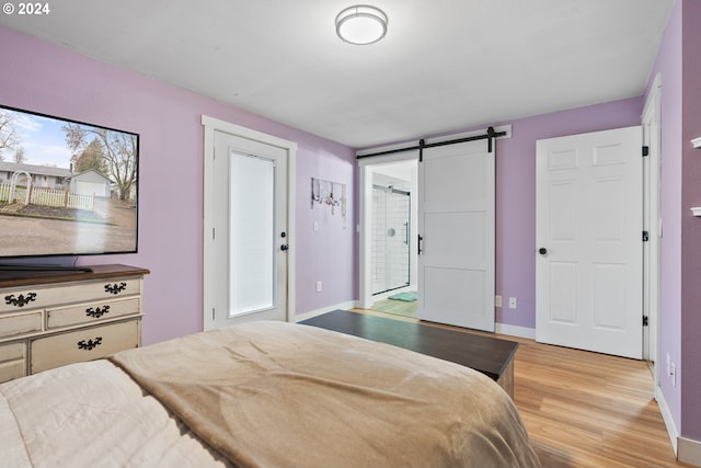 bedroom featuring a barn door and hardwood / wood-style floors