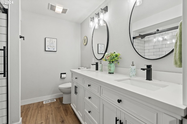 bathroom featuring hardwood / wood-style floors, vanity, toilet, and walk in shower