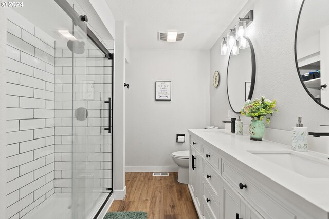 bathroom featuring toilet, vanity, an enclosed shower, and hardwood / wood-style flooring