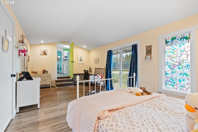 bedroom with access to exterior, lofted ceiling, and light wood-type flooring