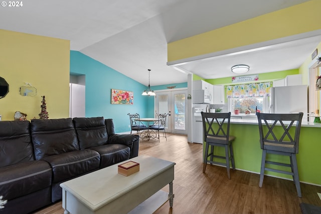 living room with french doors, wood-type flooring, and vaulted ceiling