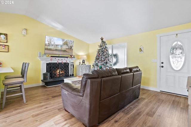 living room with light wood-type flooring, vaulted ceiling, and a healthy amount of sunlight