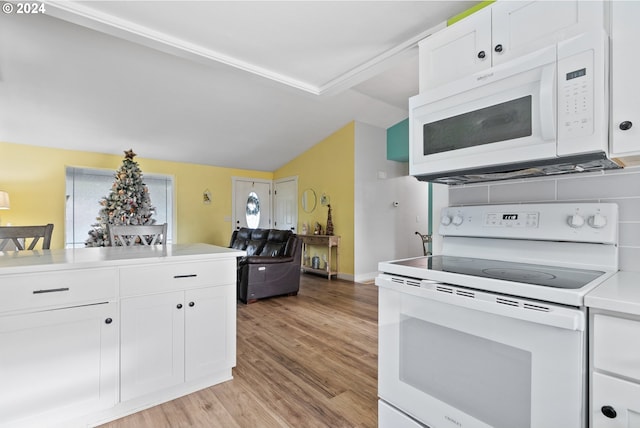 kitchen with a wealth of natural light, white cabinetry, light hardwood / wood-style flooring, and white appliances