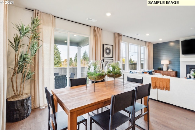 dining room featuring a large fireplace and light hardwood / wood-style flooring