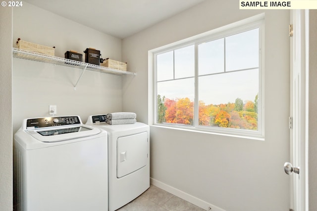 clothes washing area with independent washer and dryer and light tile patterned floors