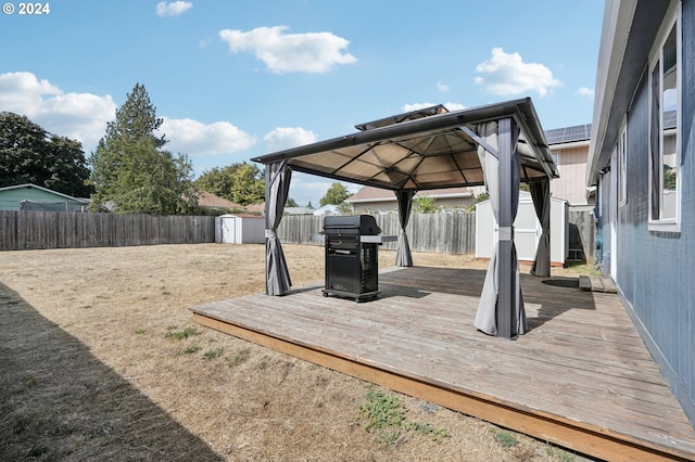 deck featuring grilling area, a gazebo, and a shed