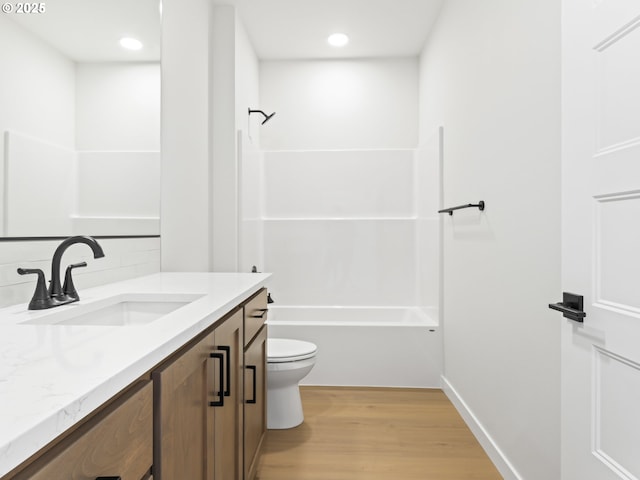 full bathroom with toilet, vanity, tasteful backsplash, wood-type flooring, and bathing tub / shower combination