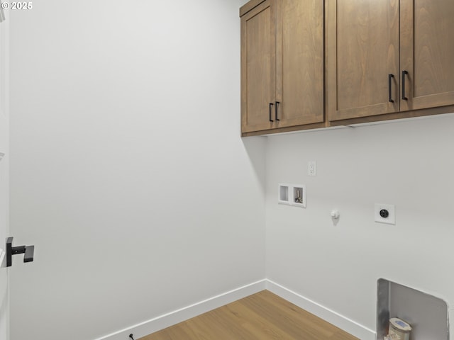 washroom featuring hookup for a gas dryer, hardwood / wood-style floors, hookup for a washing machine, electric dryer hookup, and cabinets