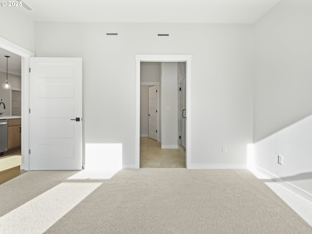 carpeted bedroom featuring sink and ensuite bathroom