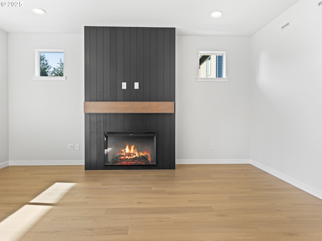 unfurnished living room with a fireplace and light hardwood / wood-style floors