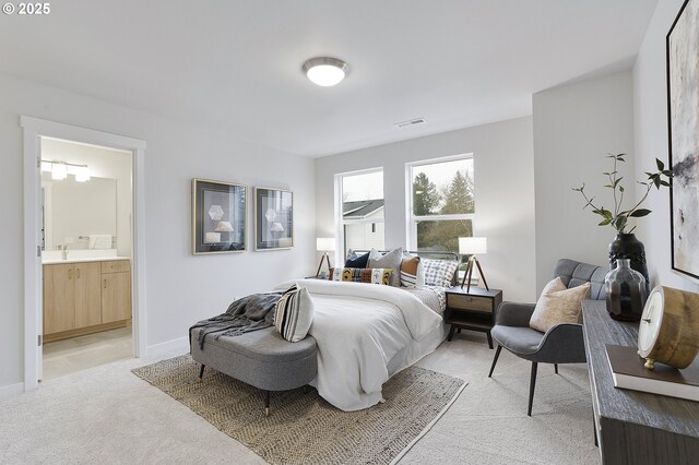 bedroom with sink, connected bathroom, and light carpet