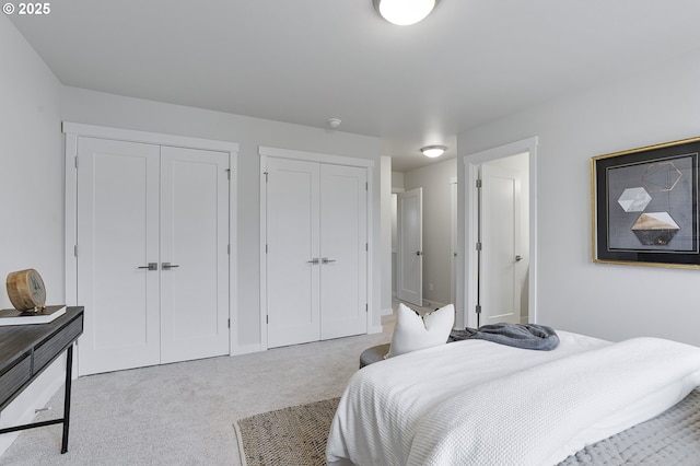 bedroom with light carpet and multiple closets