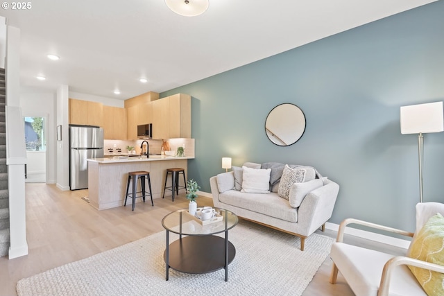 living room with sink and light hardwood / wood-style floors