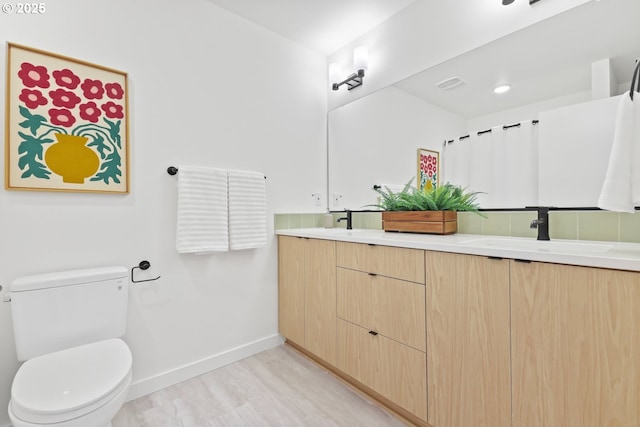 bathroom with vanity, wood-type flooring, and toilet