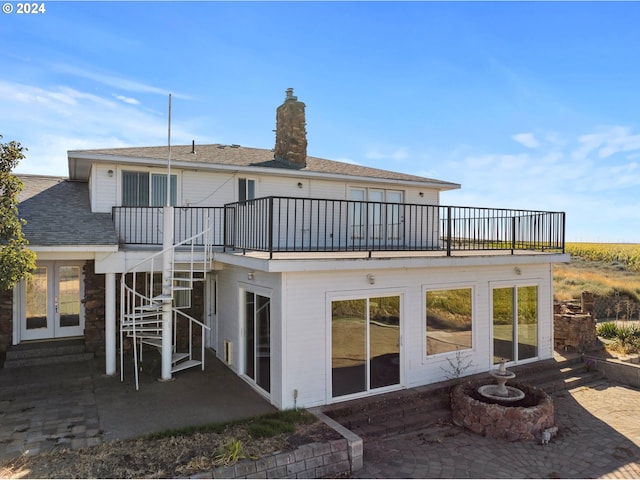 back of property featuring a patio and a fire pit