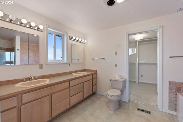 full bathroom with visible vents, a sink, toilet, and double vanity