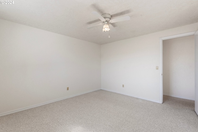 unfurnished room with light carpet, a textured ceiling, baseboards, and ceiling fan