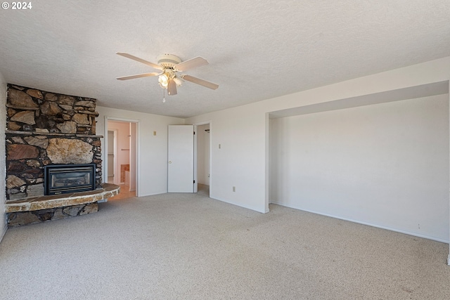 carpeted living room with ceiling fan, a fireplace, and a textured ceiling