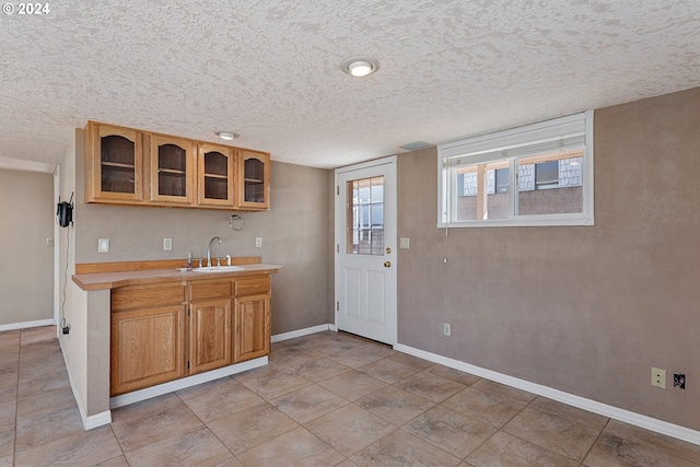 kitchen featuring a textured ceiling and sink