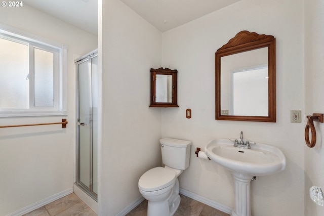 bathroom featuring tile patterned flooring, toilet, and a shower with door