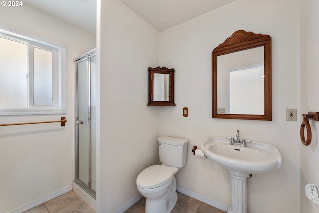 bathroom featuring toilet, baseboards, and a shower stall