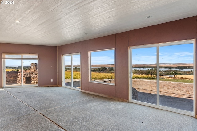 unfurnished sunroom featuring a water view