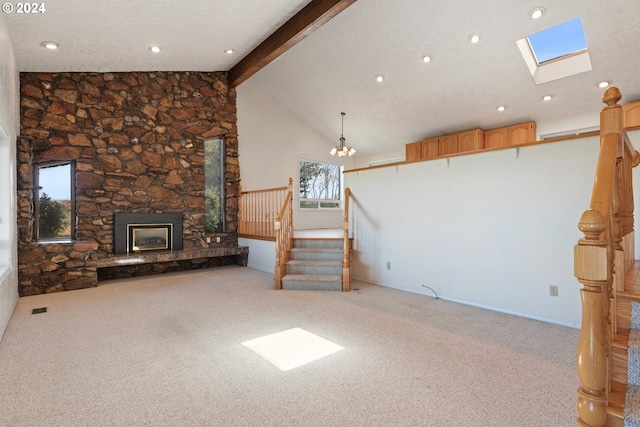 unfurnished living room featuring vaulted ceiling with skylight, light colored carpet, and a fireplace