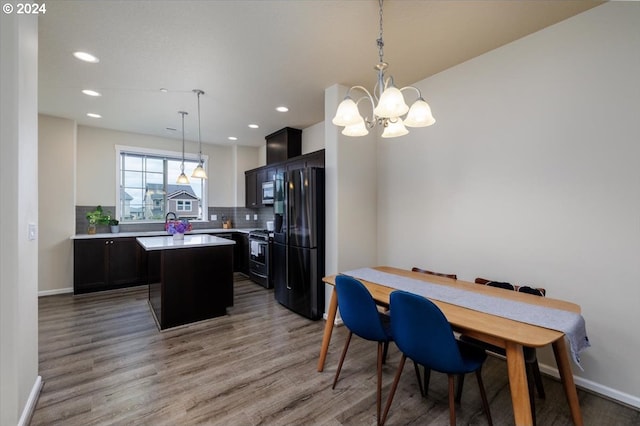 dining space with light hardwood / wood-style floors and an inviting chandelier