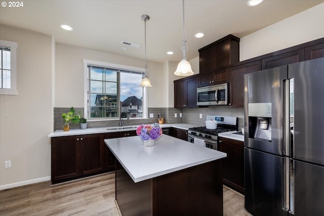 kitchen with plenty of natural light, a center island, appliances with stainless steel finishes, and light hardwood / wood-style flooring