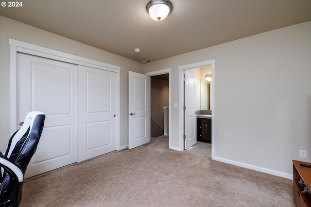 office featuring a textured ceiling and light carpet