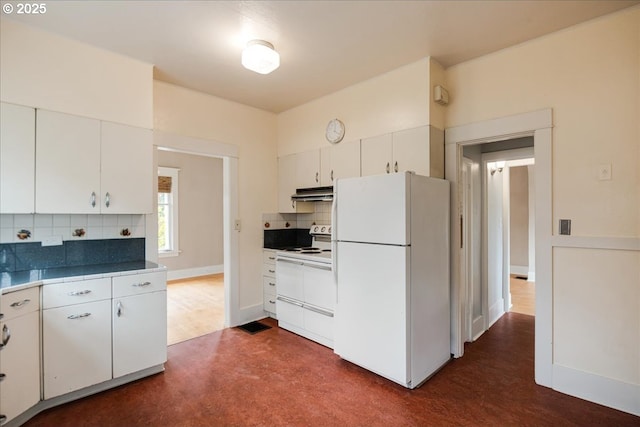 kitchen featuring white appliances, white cabinets, decorative backsplash, dark countertops, and under cabinet range hood