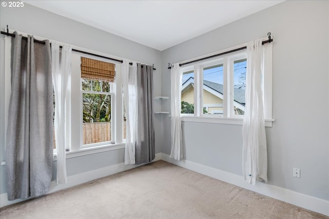 empty room featuring light carpet and baseboards