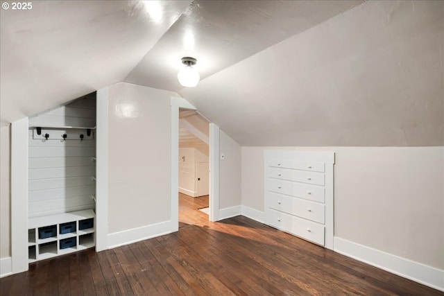 additional living space with dark wood-style floors, lofted ceiling, and baseboards