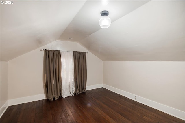 bonus room with vaulted ceiling, dark wood finished floors, and baseboards