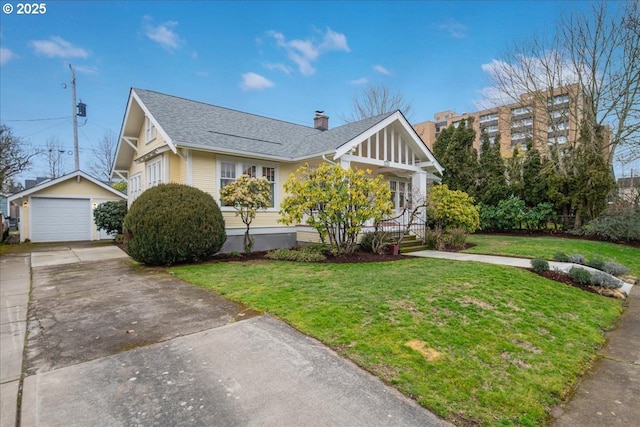 view of front of home featuring a garage, an outbuilding, concrete driveway, and a front lawn