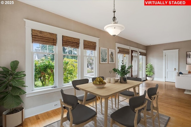 dining area featuring light wood finished floors and baseboards