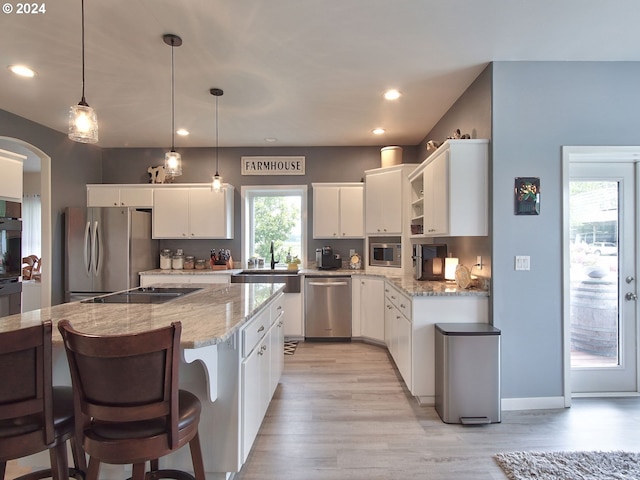 kitchen featuring decorative light fixtures, white cabinetry, a healthy amount of sunlight, and black appliances