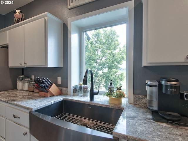 kitchen featuring sink and white cabinets