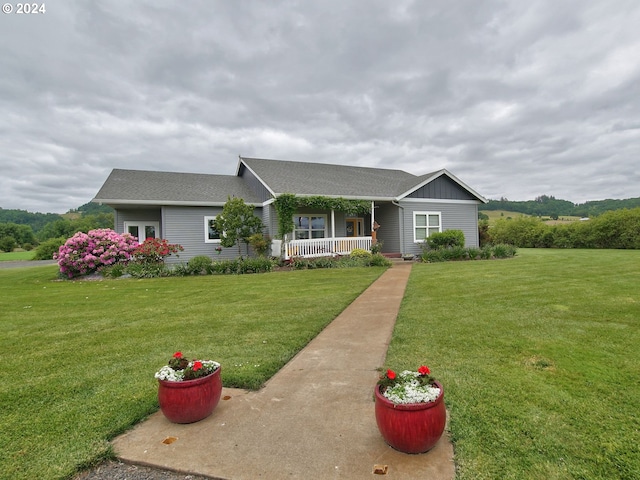 ranch-style home featuring covered porch and a front lawn