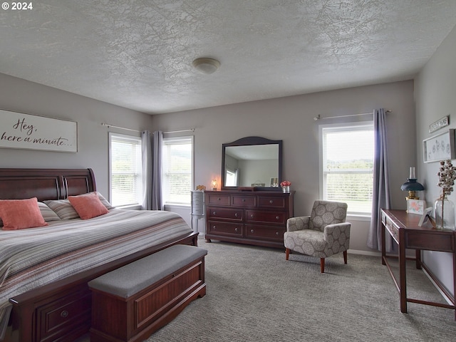 carpeted bedroom with a textured ceiling and multiple windows