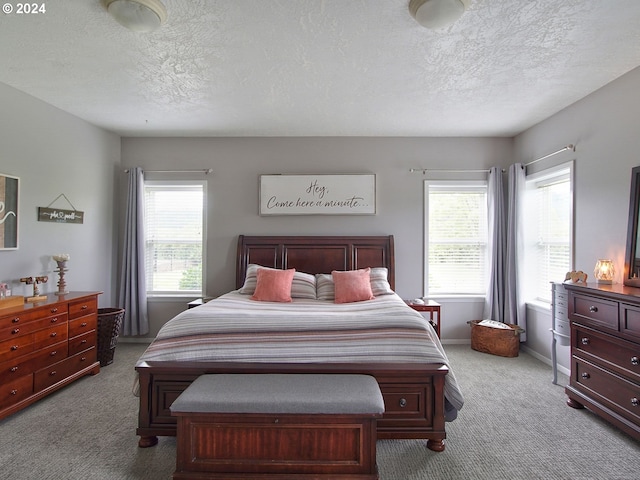 bedroom featuring light carpet and a textured ceiling