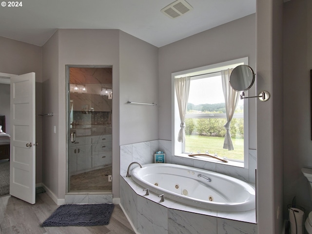 bathroom with plus walk in shower and hardwood / wood-style flooring