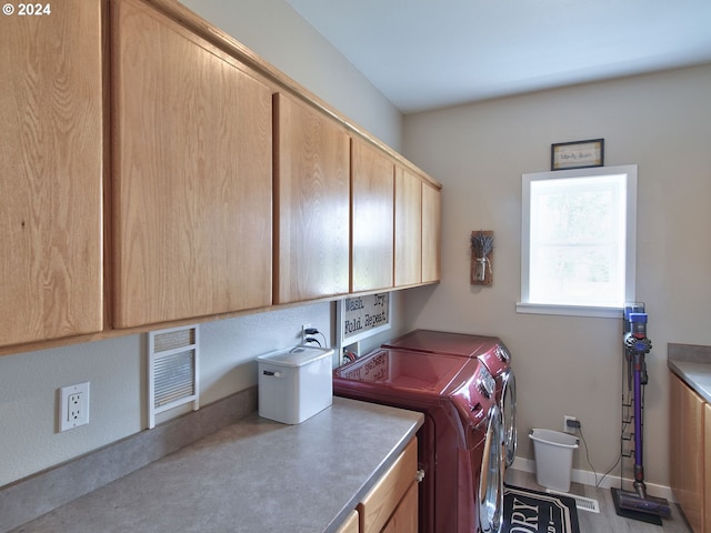 washroom featuring cabinets and washer and dryer