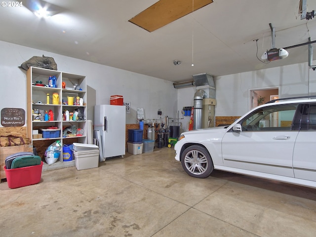 garage featuring white refrigerator and a garage door opener