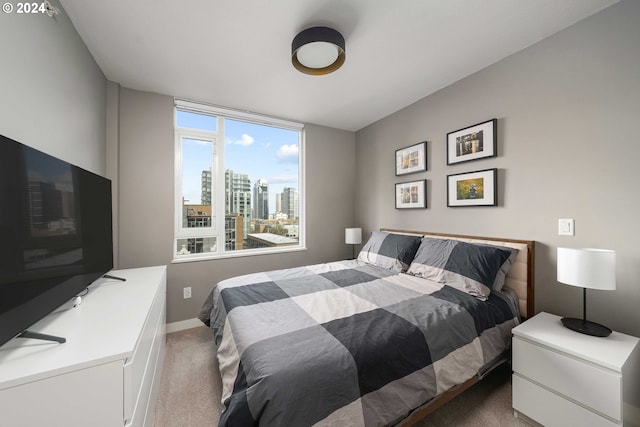 carpeted bedroom featuring baseboards and a city view